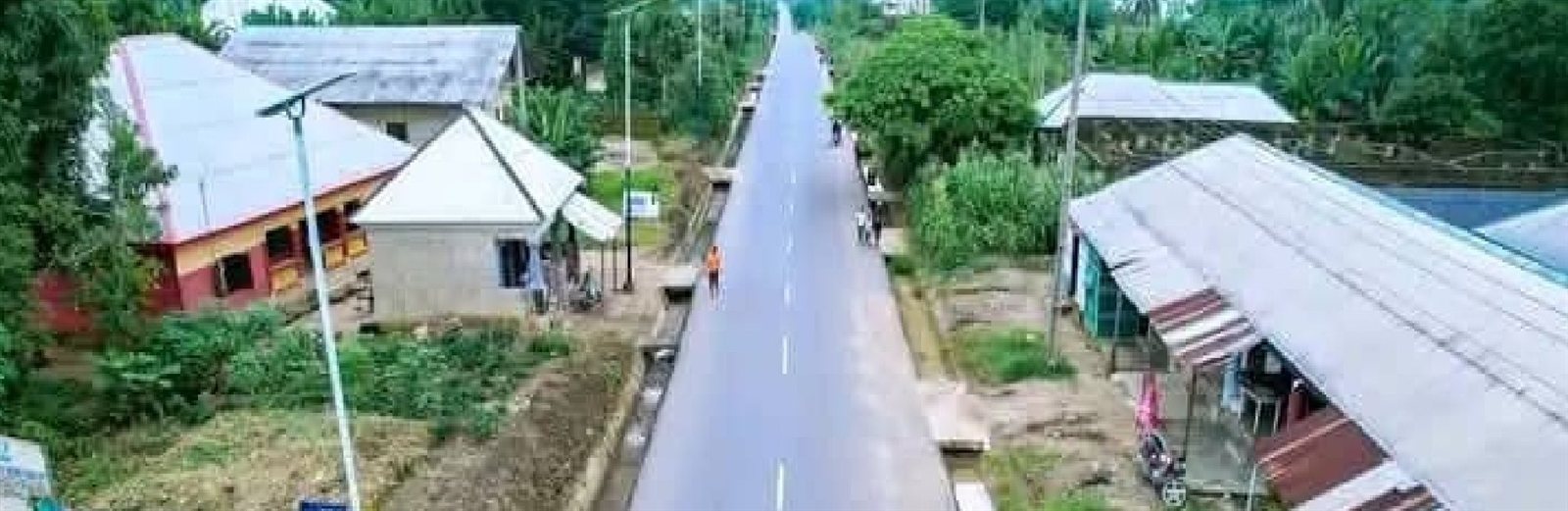 Low aerial view of the completed asphalt road through the town