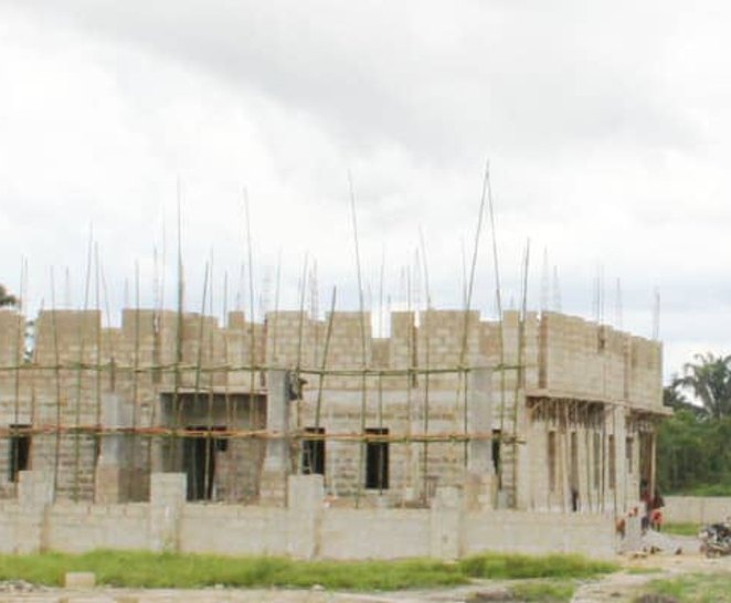 Wide view of the lodge walls rising behind a low fence