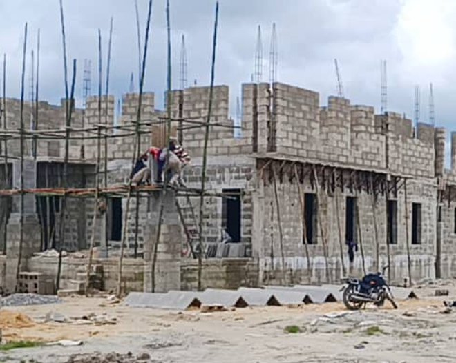 Lodge walls with scaffolding and workers at a distance