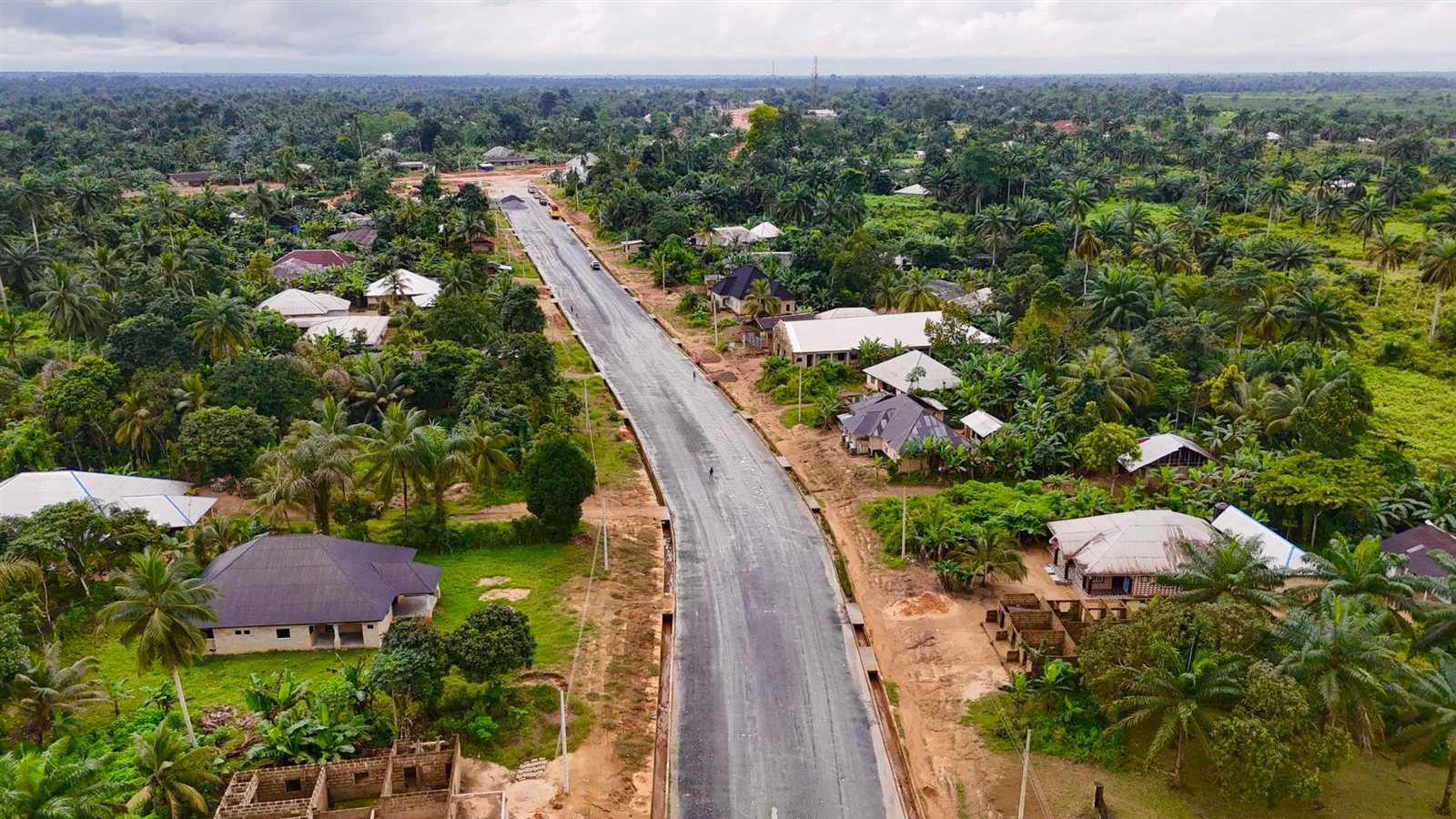 Drone view along the carriageway towards the junction, asphalt laid with side drains on both sides