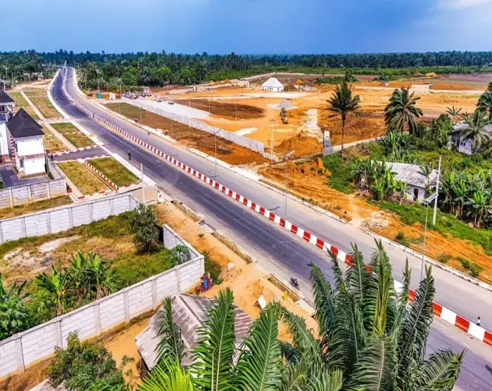 Aerial view of a dualised road in Eket with homes and palm trees on both sides