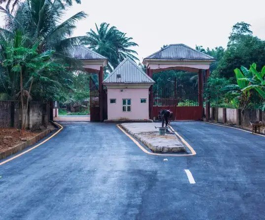 Asphalt road leading to the university entrance gate
