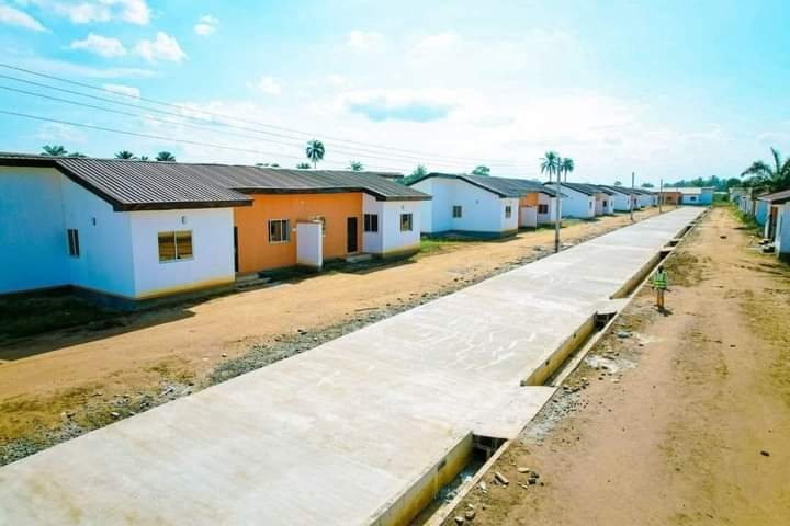 A street of finished houses with a concrete road and drain