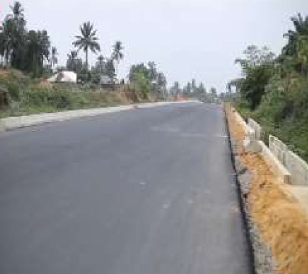 Newly asphalted stretch of the road with a drainage channel beside it