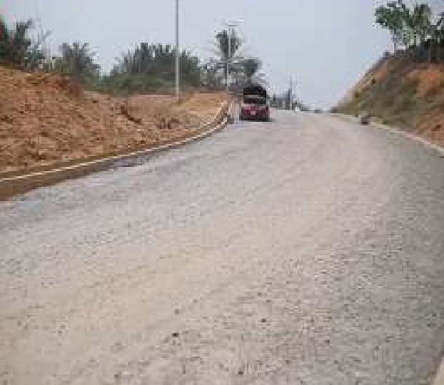 Gravel base laid on the road beside a cut slope and kerb