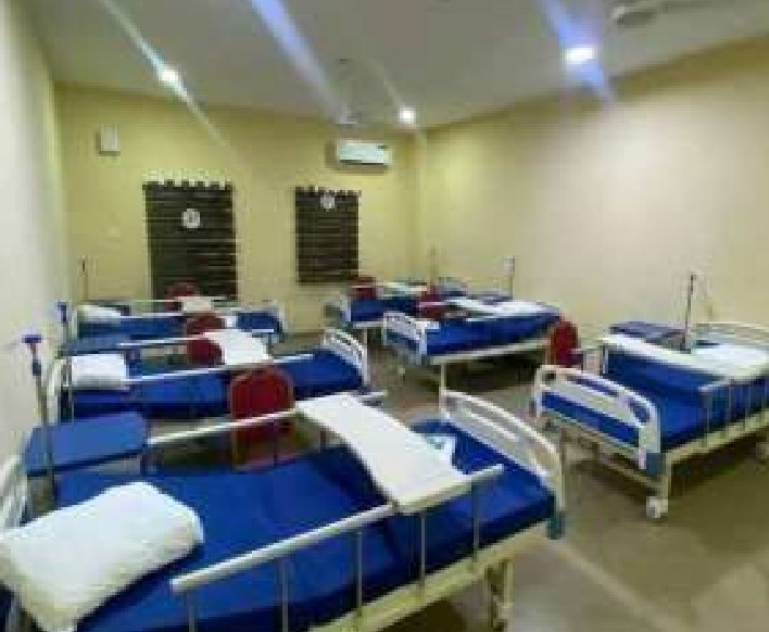 Hospital ward with rows of blue-covered beds