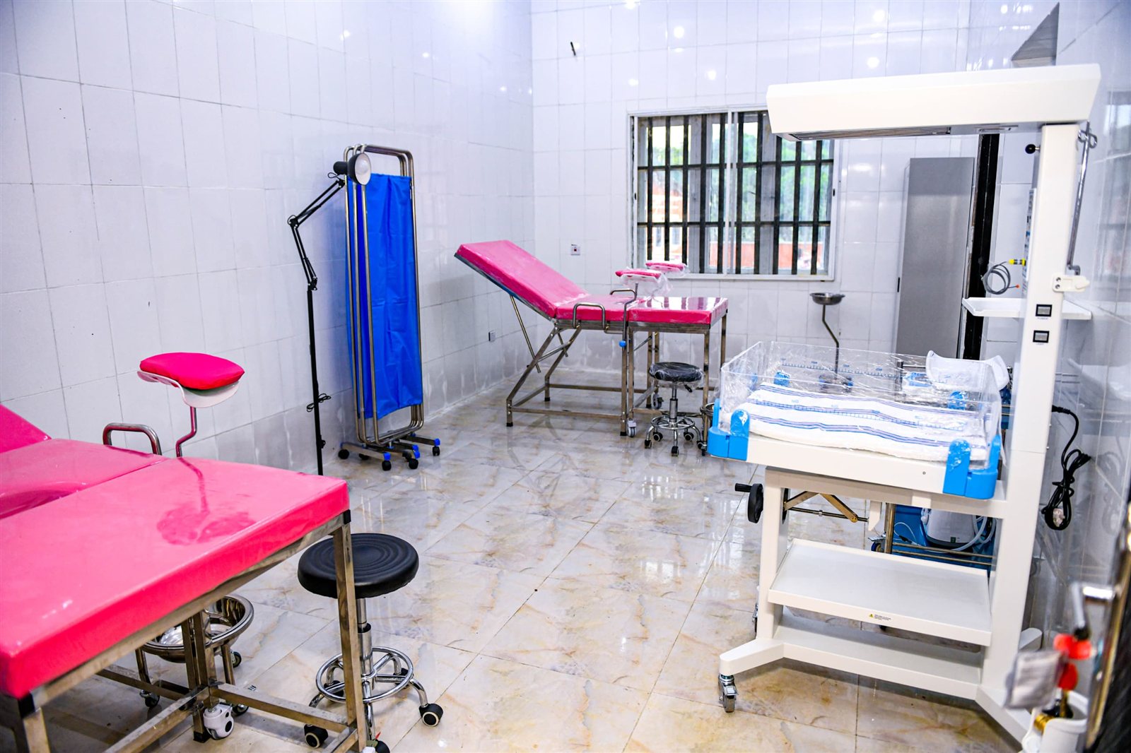 Tiled delivery room with delivery beds, a screen and a baby warmer