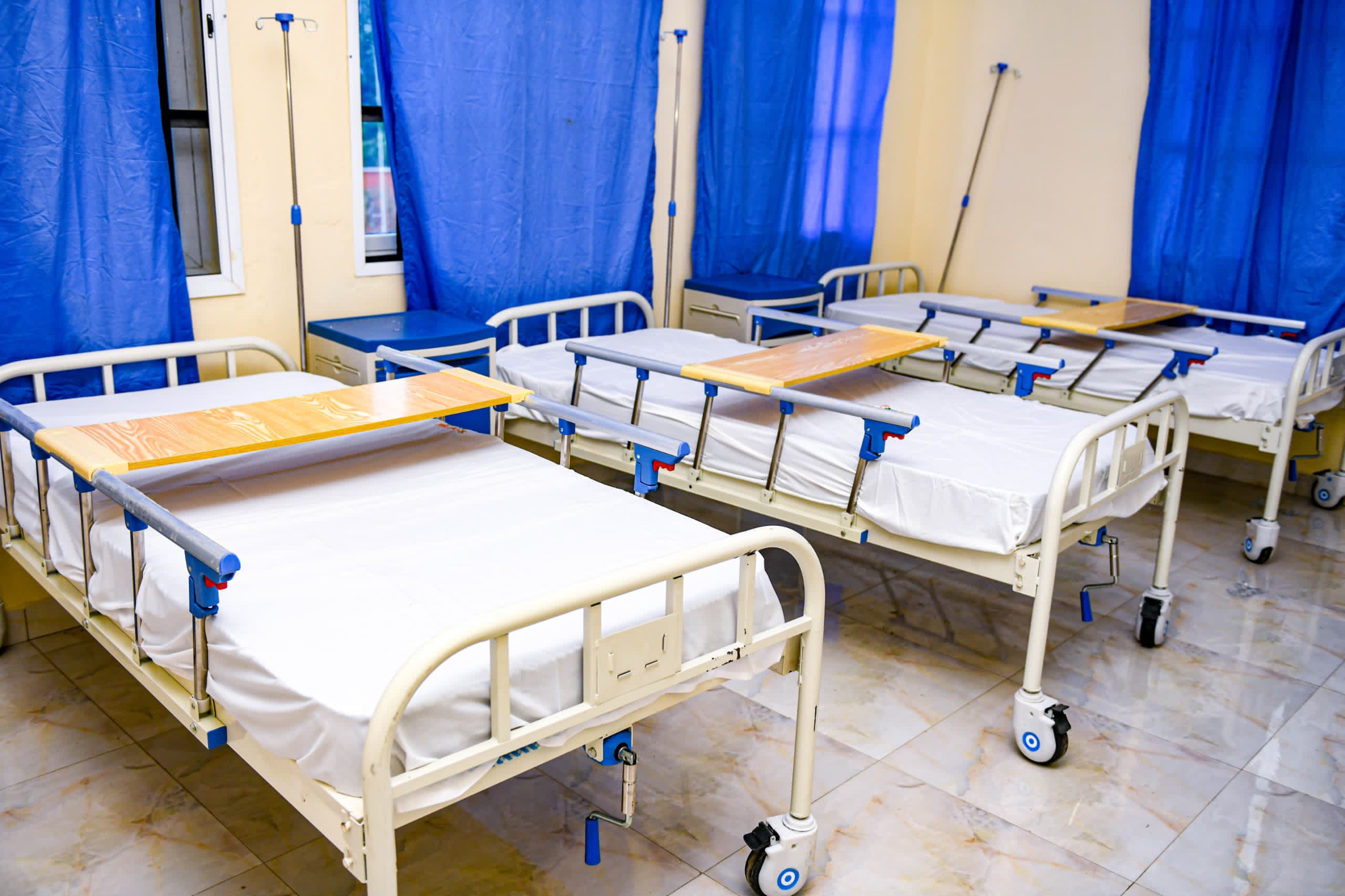 Ward with new hospital beds, drip stands and bedside lockers