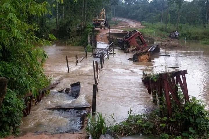The old Nto Ide crossing washed out by floodwater, broken timber deck and a toppled machine in the river