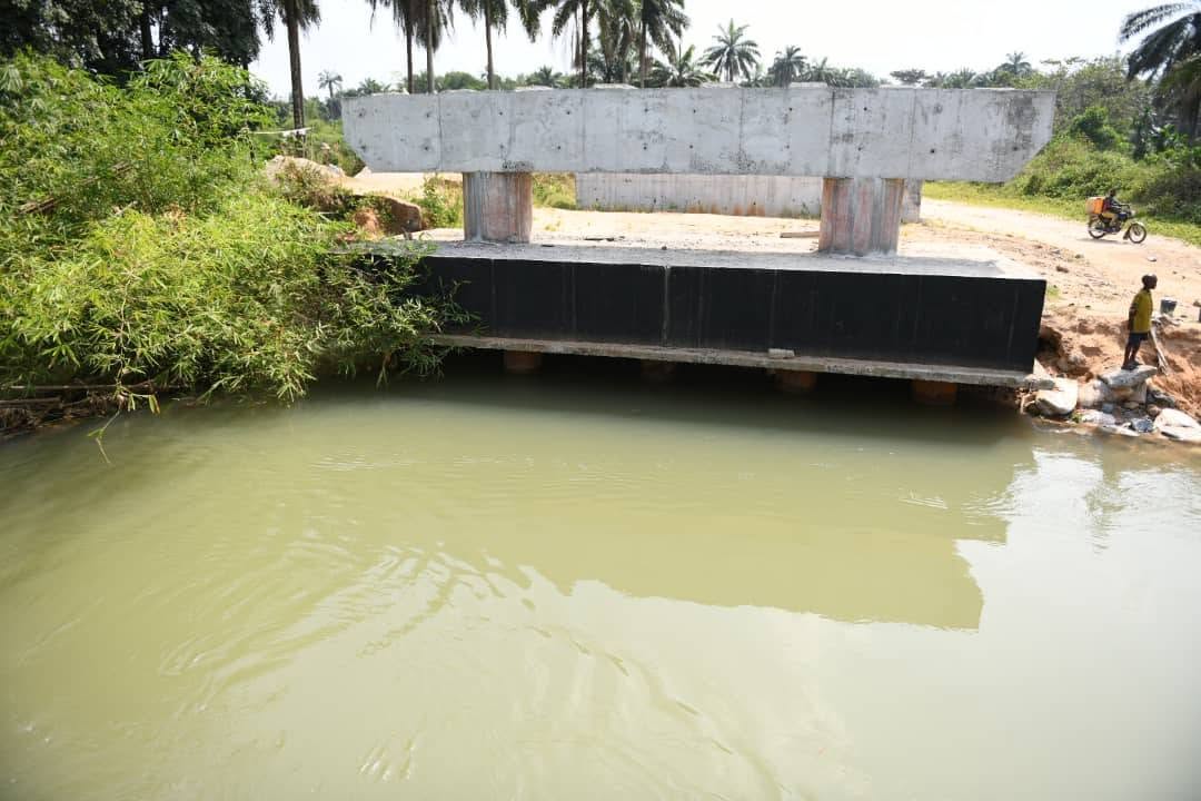 Bridge pier and beams on the river bank with the black-coated abutment wall at the crossing site