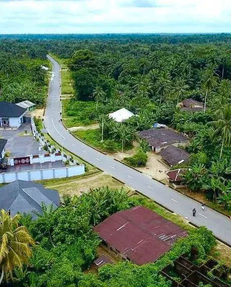 Aerial view of a completed road through a community in Mkpat Enin