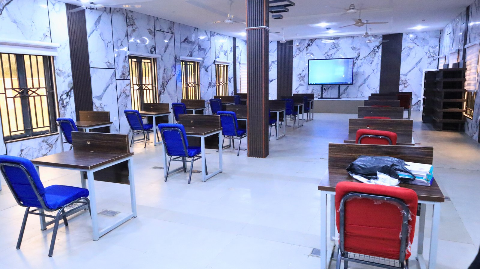 A training room with desks and a screen