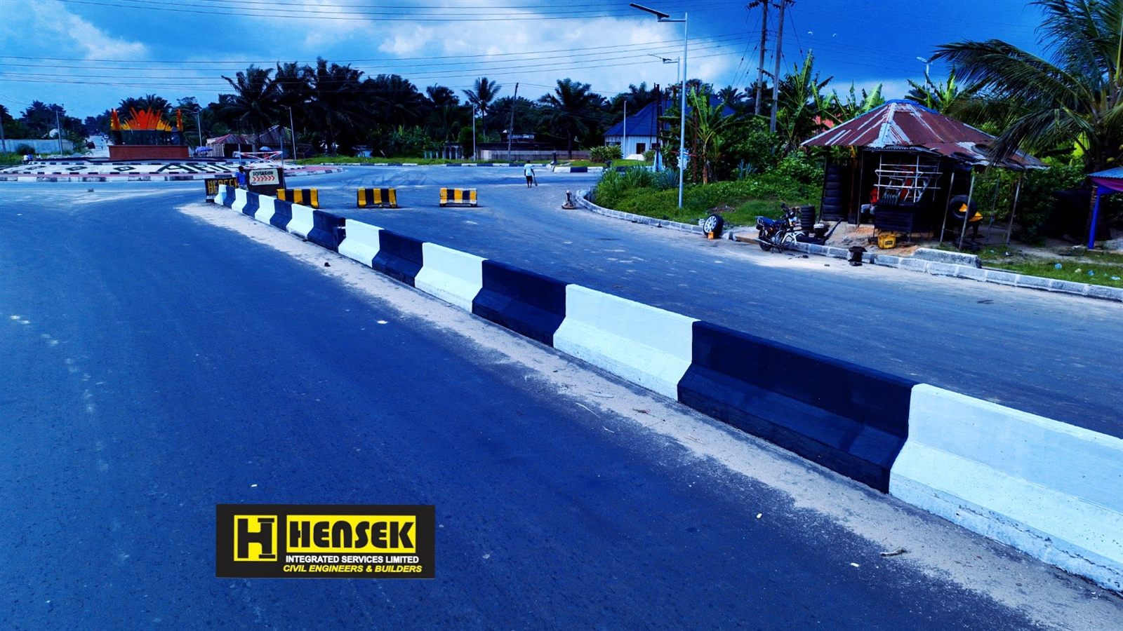 Painted median barriers and a roundabout ahead on the dual carriageway