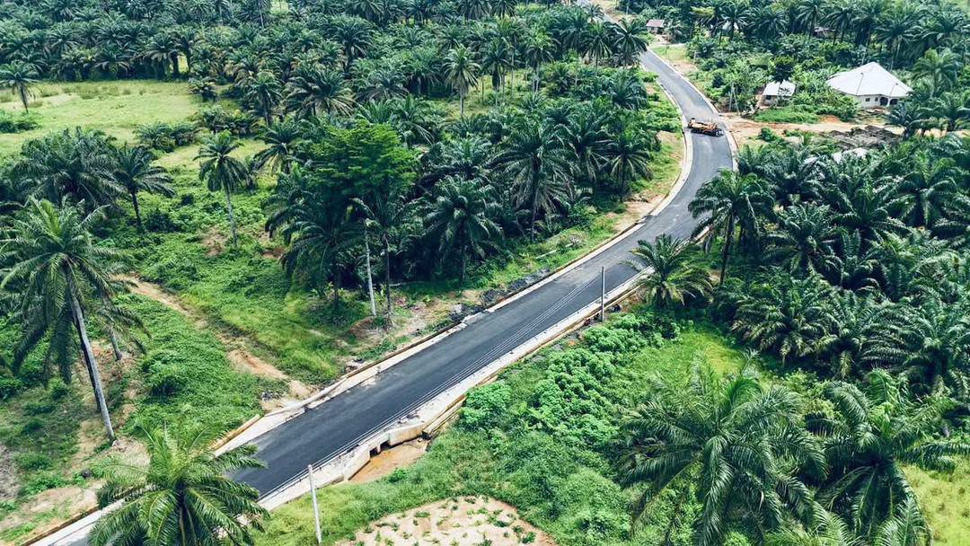 Aerial view of a winding new asphalt road with a culvert crossing