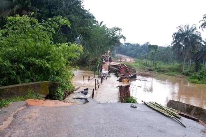 The collapsed old crossing seen from the road end, broken deck and floodwater below