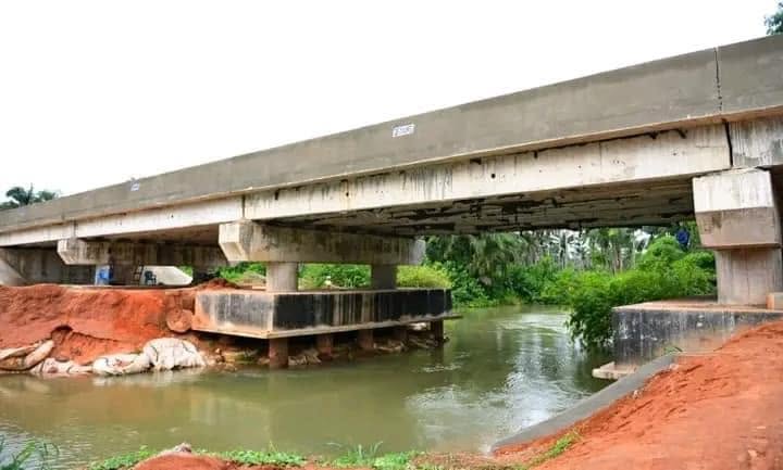 Bridge beams on concrete piers over the river with the abutment and sandbags at the bank