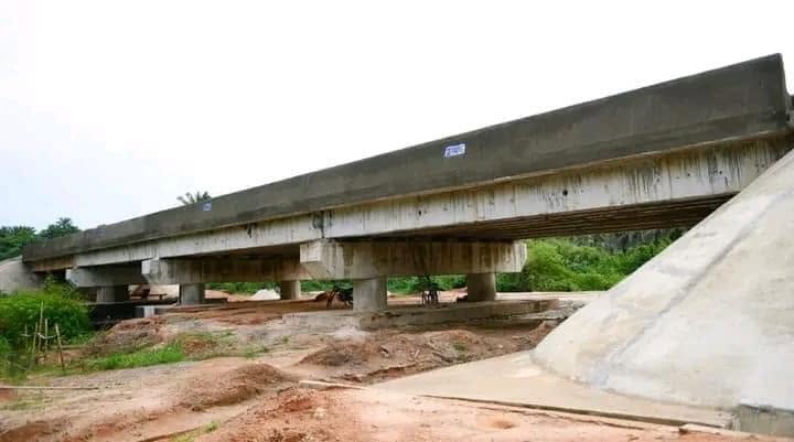 Side view of the bridge beams on concrete piers with the finished abutment slope at right