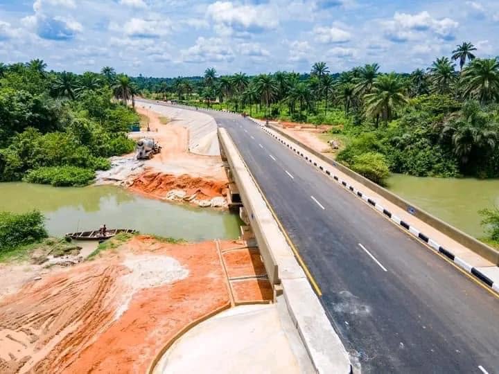 Finished bridge deck with marked lanes, kerbs and railings crossing the river, seen from above