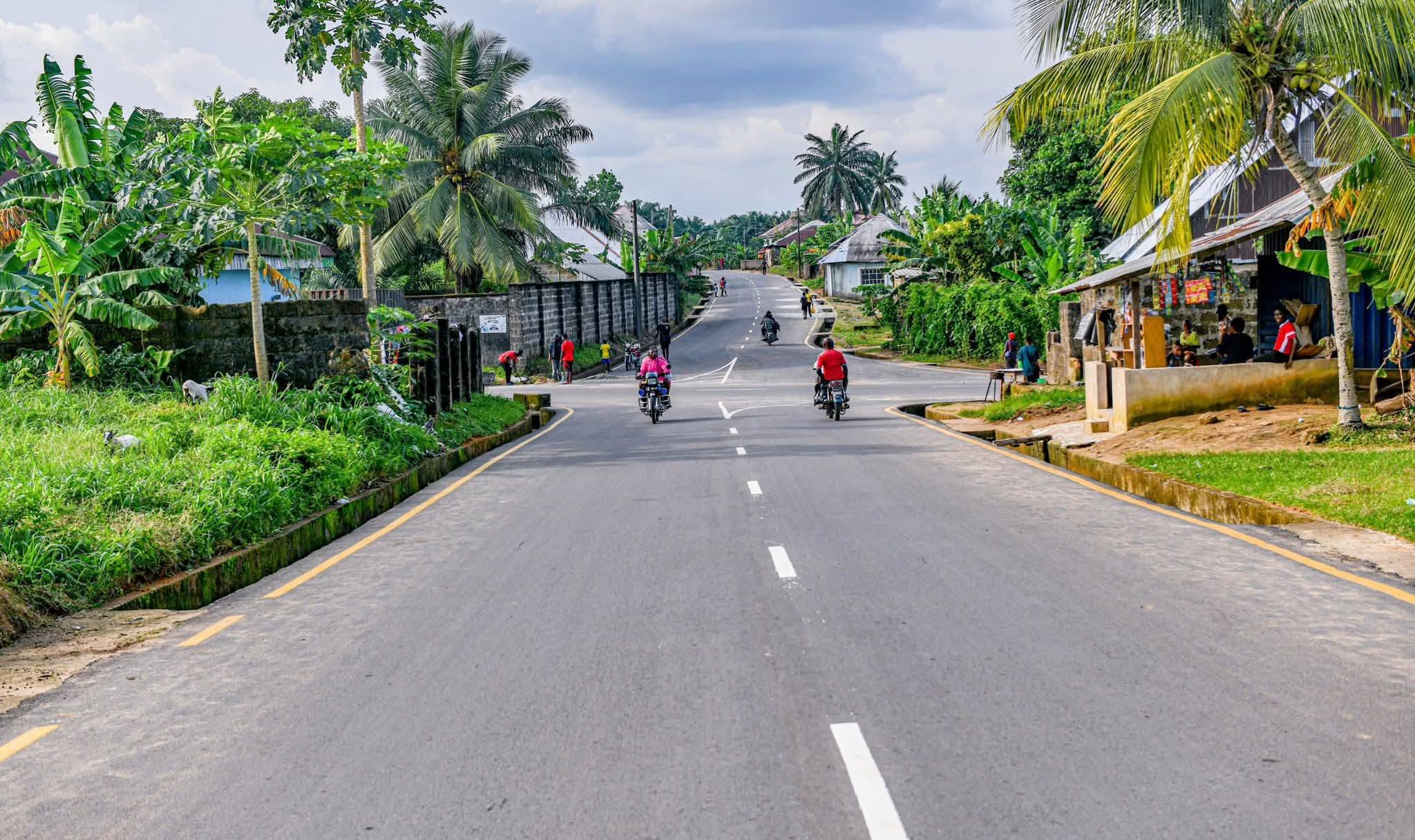 Newly asphalted street in Oron town with lane markings and concrete side drains