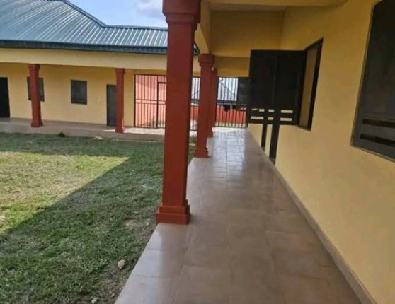 Covered walkway with red pillars beside a classroom block