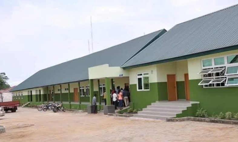 Long hospital block with green roof and a paved forecourt