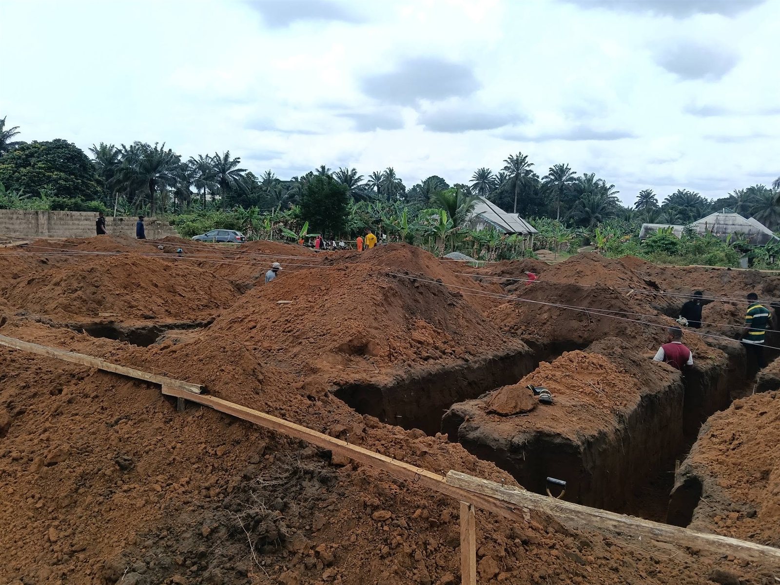 Workers digging foundation trenches across the site