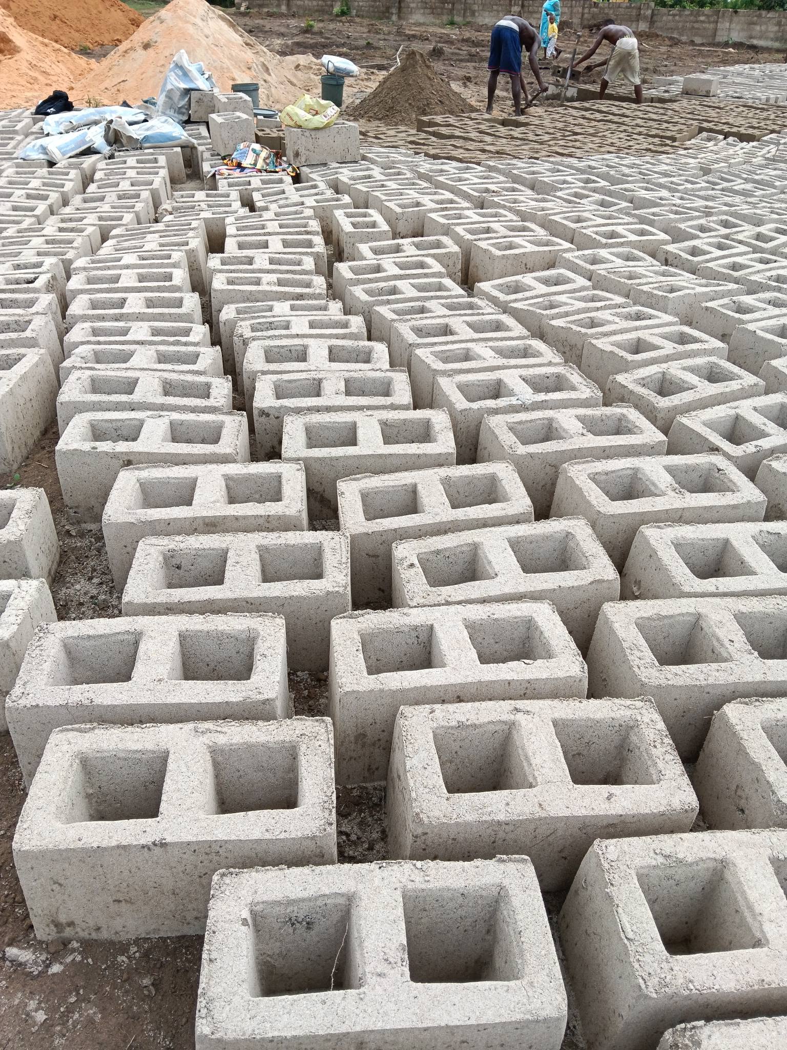 Rows of sandcrete blocks moulded on site for the building