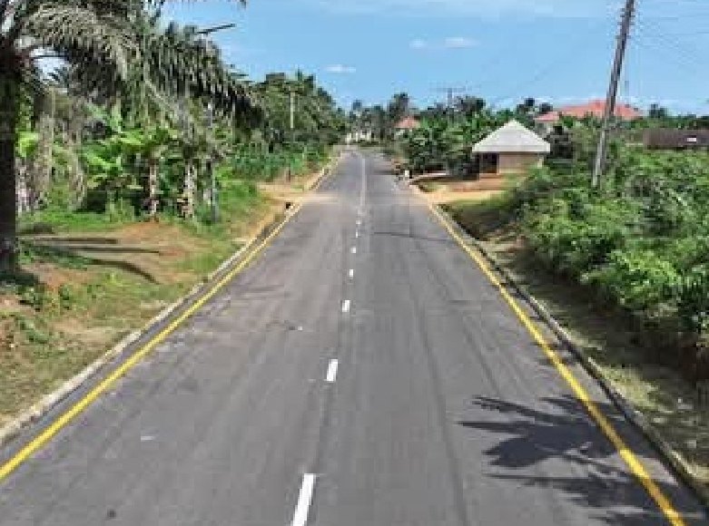 Newly asphalted road with yellow edge lines through a village