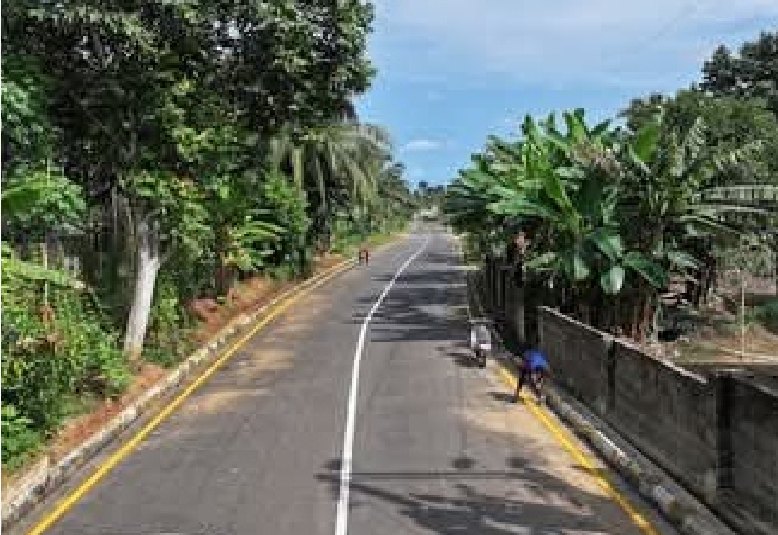 Straight stretch of the new road beside a boundary wall