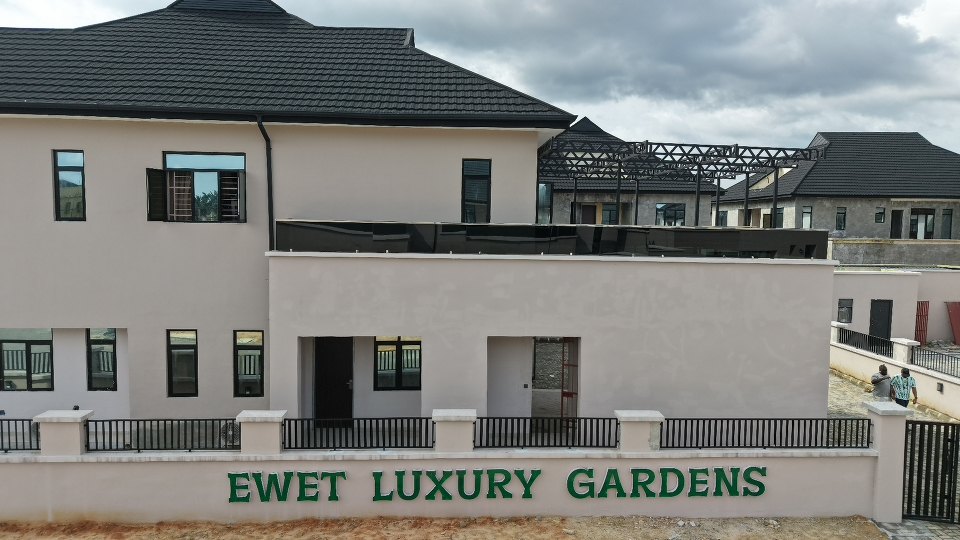 A house at the entrance with the estate name on the wall