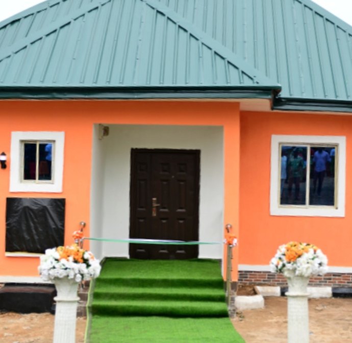 Newly built orange bungalow with green roof and grass walkway