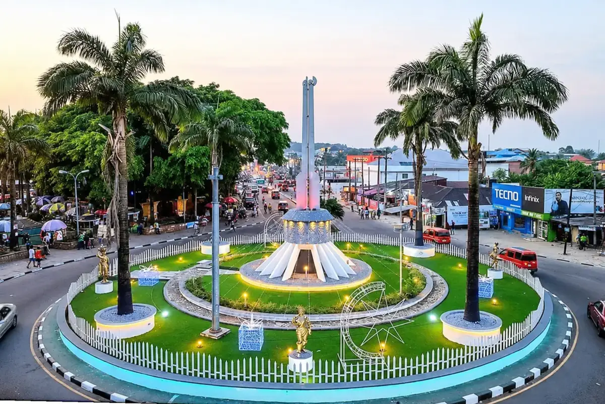 A roundabout with a monument and palm trees in Uyo