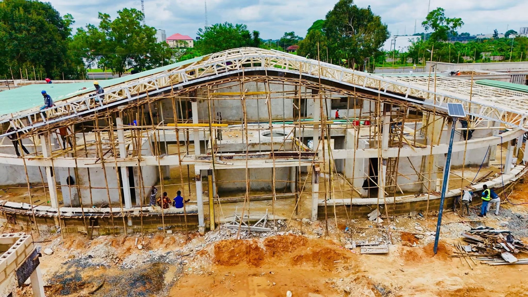 Builders on the roof frame and scaffolding of the main building